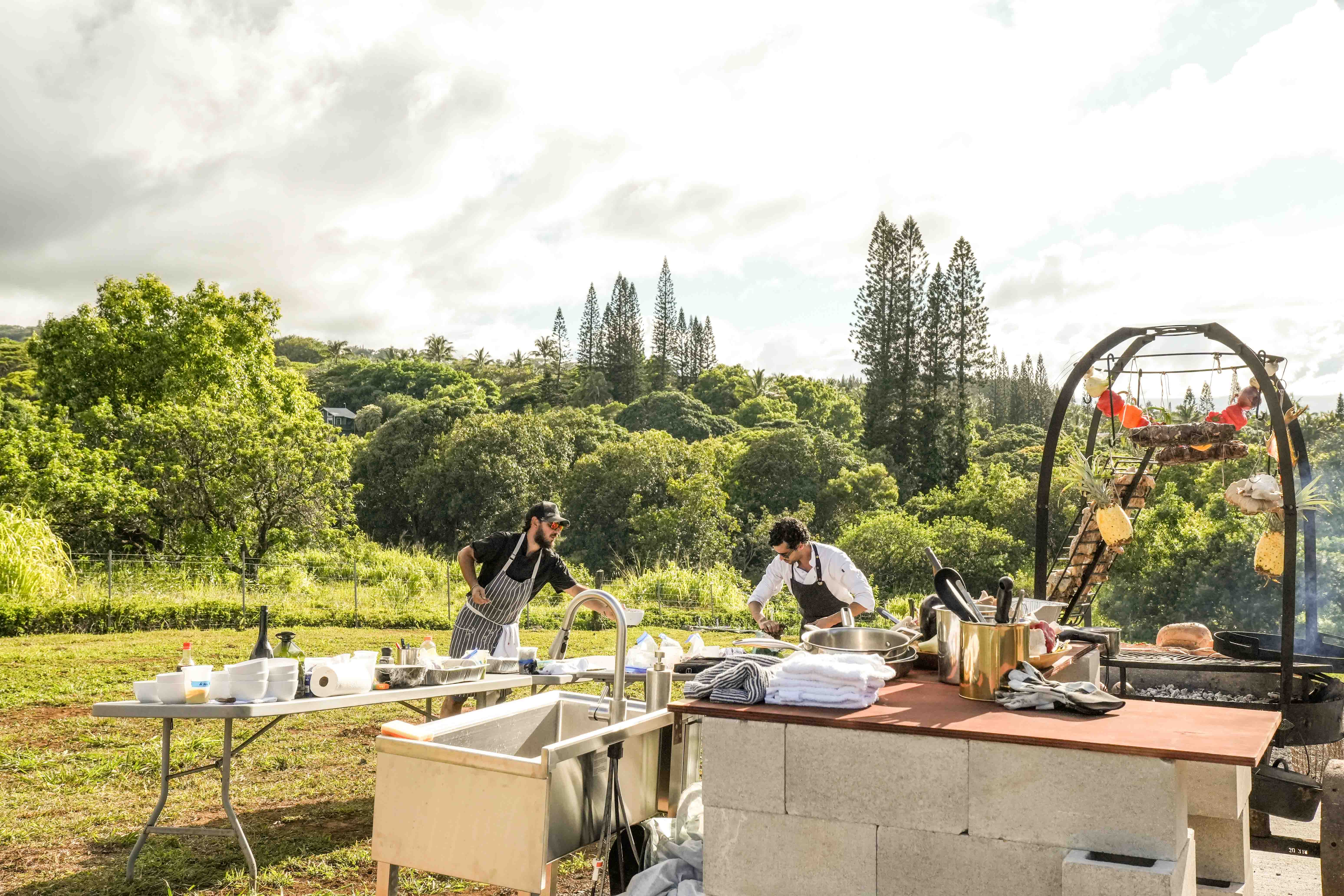 Chef Agustin and crew at the open-air farm kitchen with the north-shore hills behind